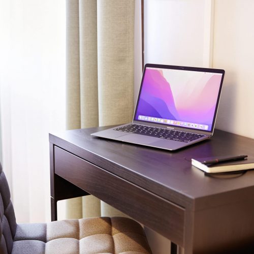 Auf diesem Bild ist ein Schreibtisch mit einem Laptop zu sehen.